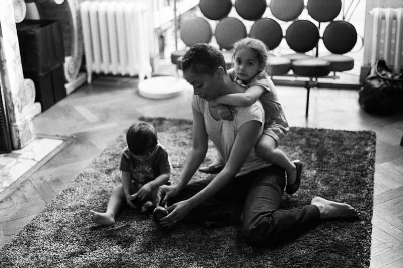 A mother plays on the floor with her son and daughter