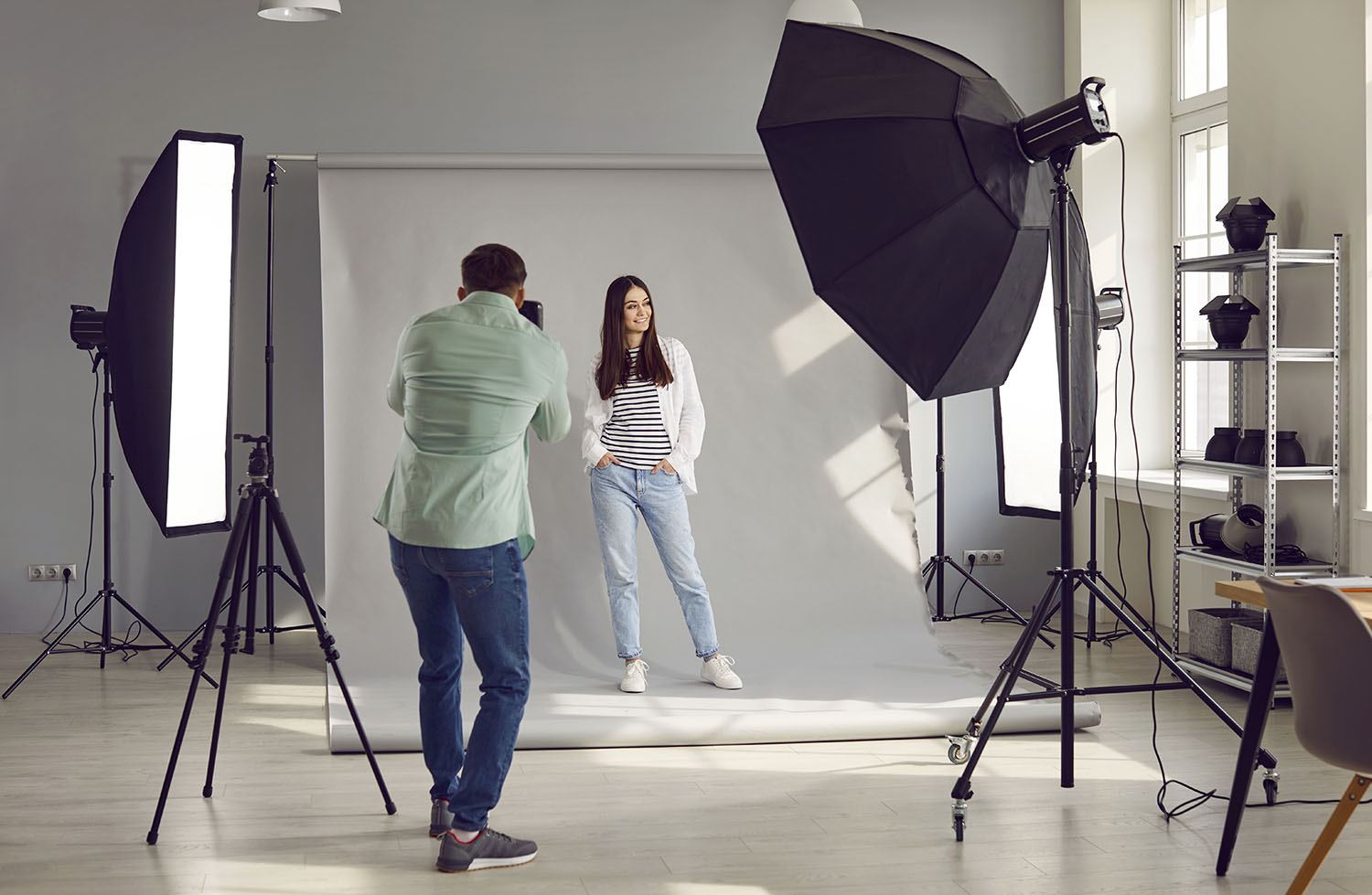 Une femme pose pour un photographe lors d'une séance photo d'entreprise en studio.